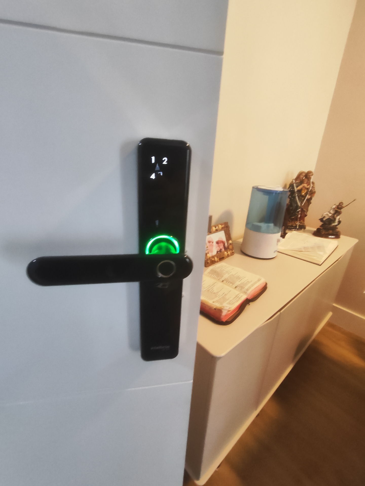 Intelbras com biometria iluminada em porta branca