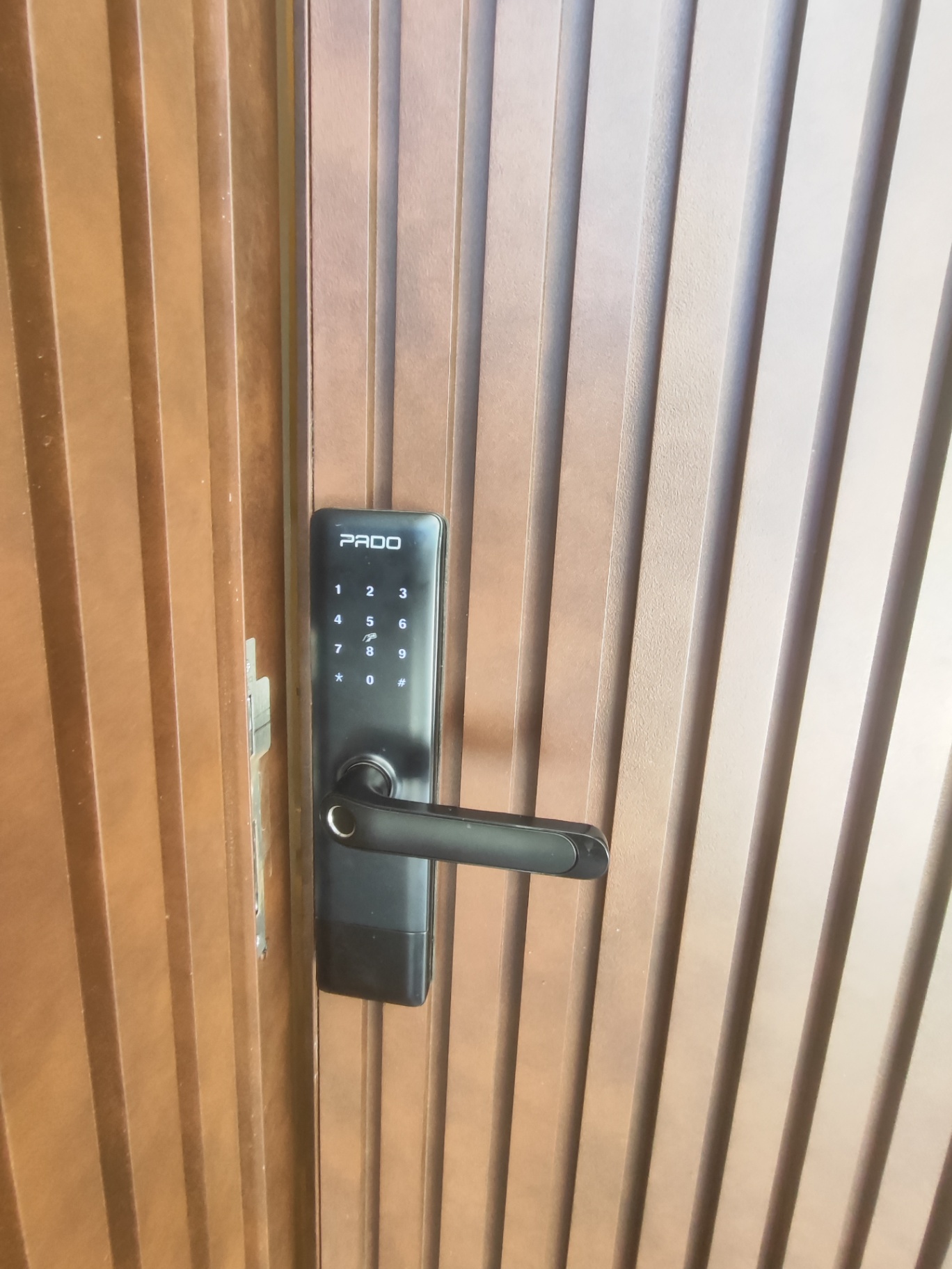 Pado com teclado touch em porta de madeira ripada